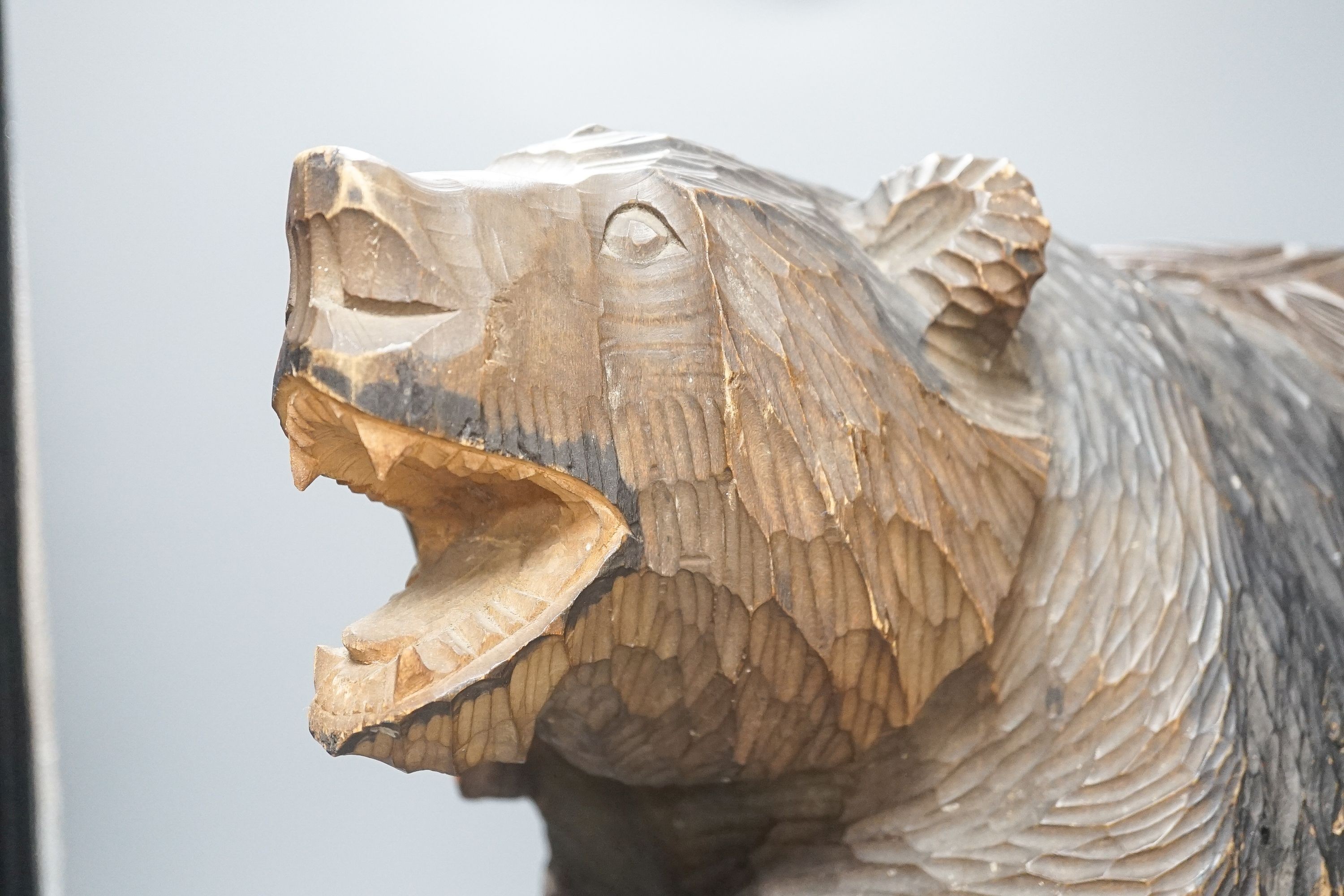 A large Japanese carved wooden bear holding a fish, inscribed 47cm